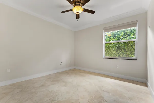 an empty room with a window and a ceiling fan