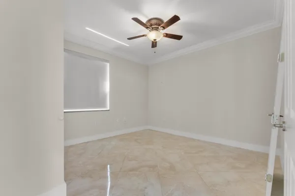 an empty room with windows and fan