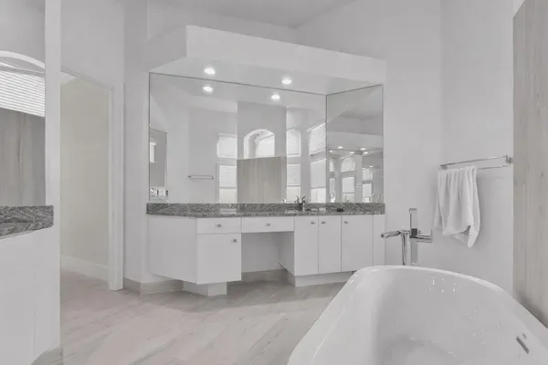 a bathroom with double vanity and a bathtub