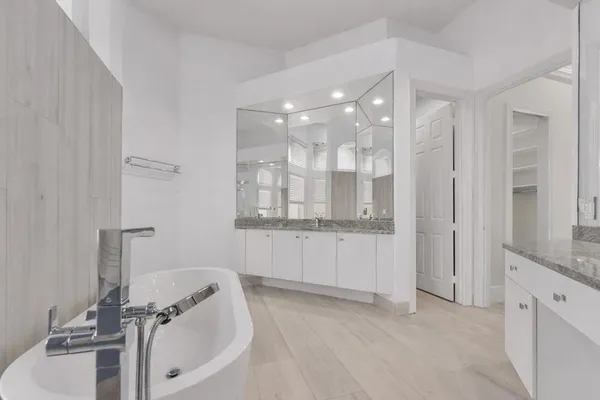 a bathroom with a tub sink and mirror