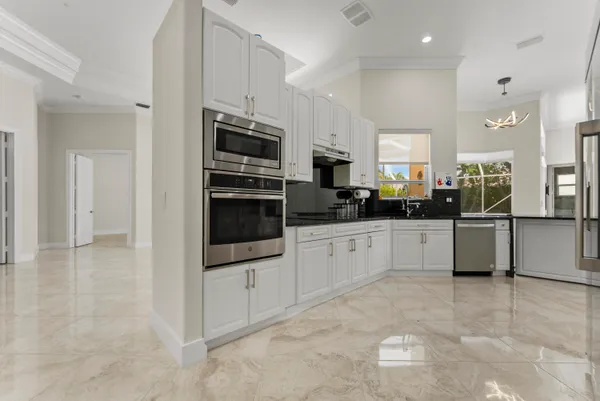 a kitchen with stainless steel appliances a refrigerator sink and white cabinets