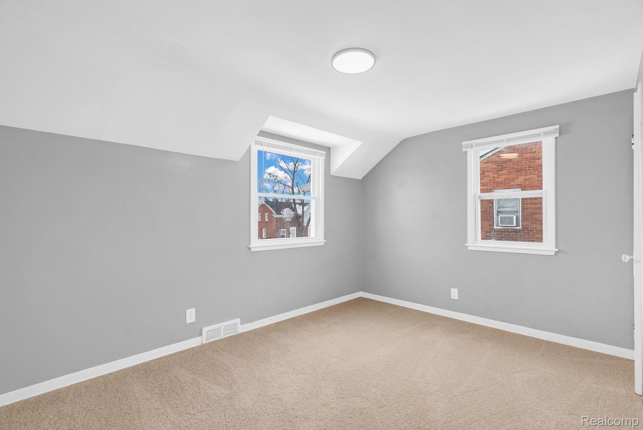 10808 Nottingham Road Detroit, MI 48224 - Photo 15 of 26 Additional living space featuring lofted ceiling, light carpet, and healthy amount of natural light