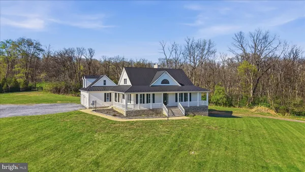 a front view of a house with a yard and potted plants