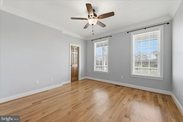a view of an empty room with a ceiling fan and a window