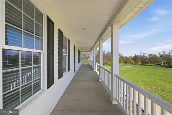 a view of a hallway with wooden floor and a living room