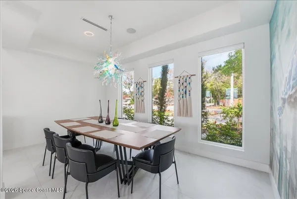 a dining room with furniture a chandelier and kitchen view