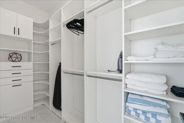 a spacious bedroom with a bed and a flat screen tv