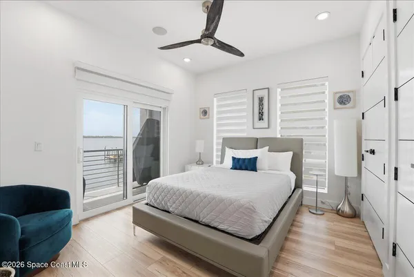 a front view of a house with a garden and lake view