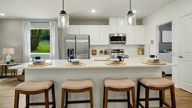 a kitchen with a sink and chairs
