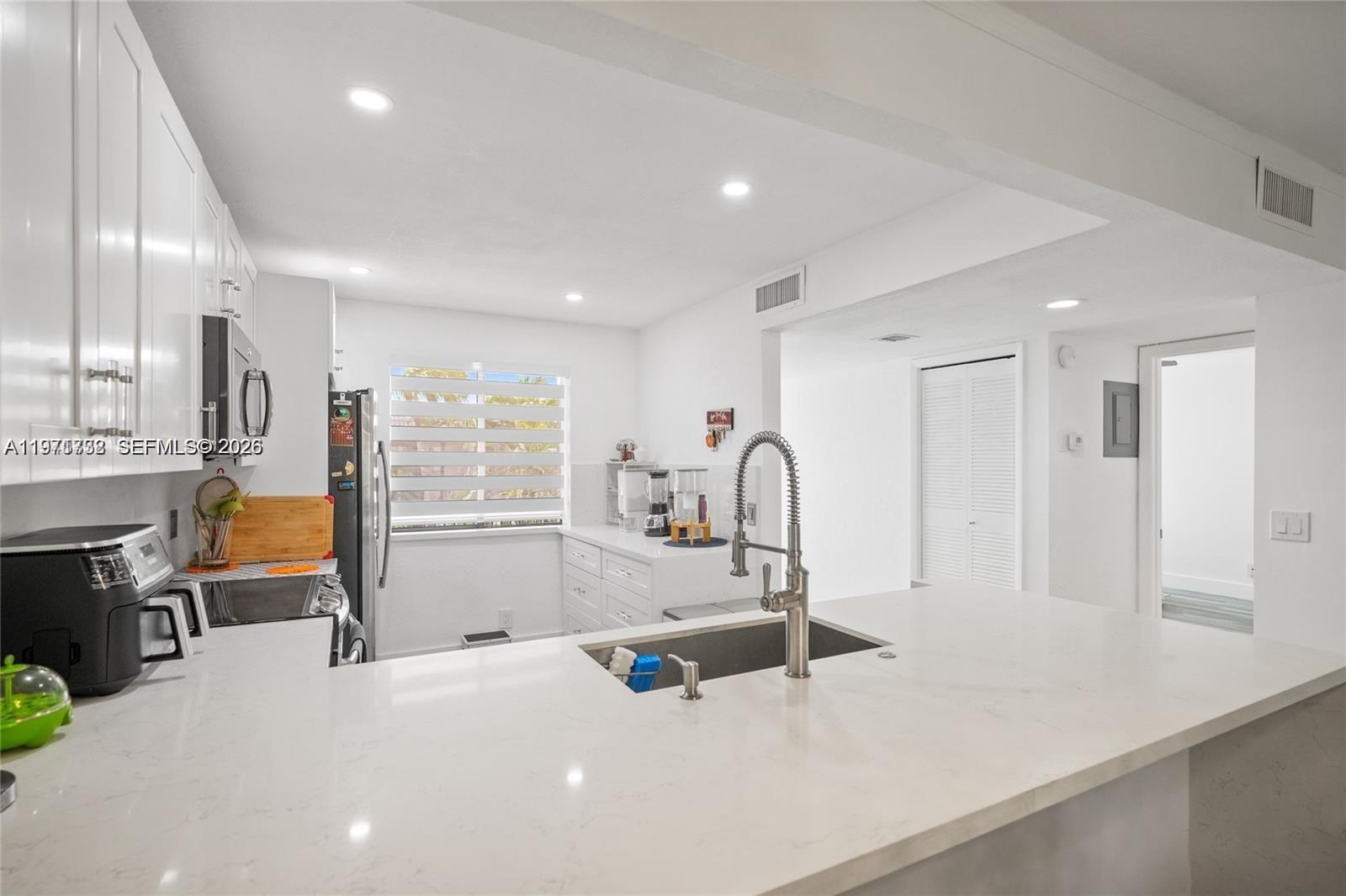 380 Racquet Club Road, Unit 204 Weston, FL 33326 - Photo 5 of 15 a kitchen with stainless steel appliances a sink and a refrigerator