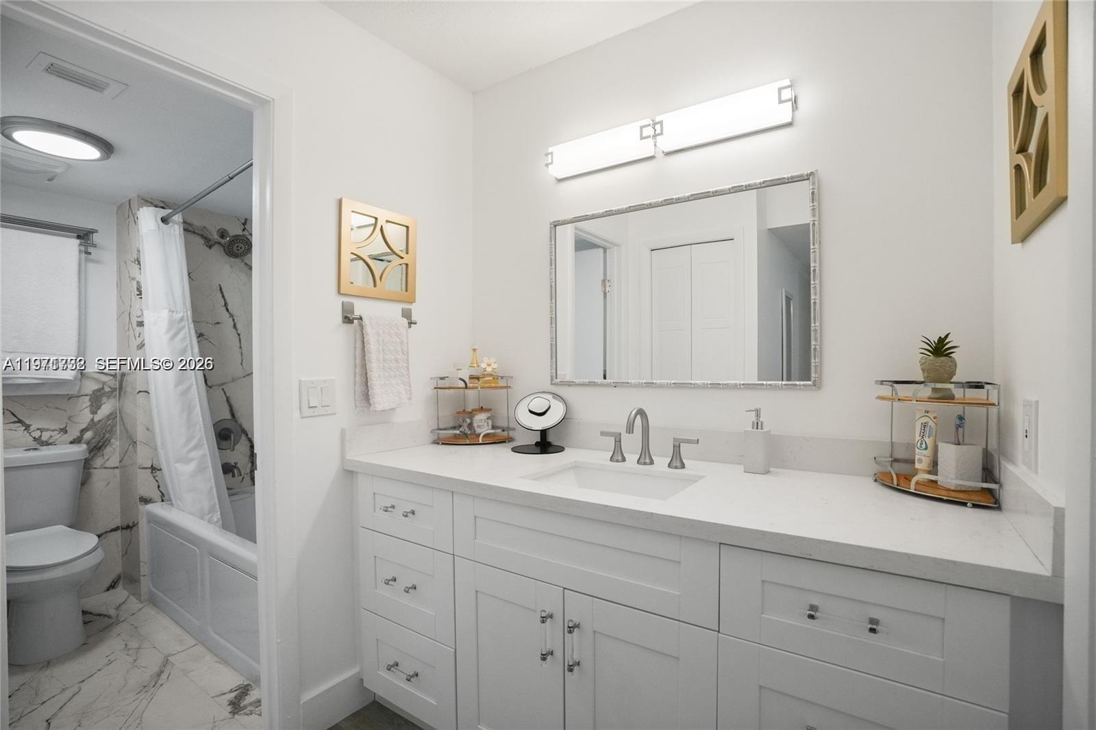 380 Racquet Club Road, Unit 204 Weston, FL 33326 - Photo 9 of 15 a bathroom with a toilet sink and mirror