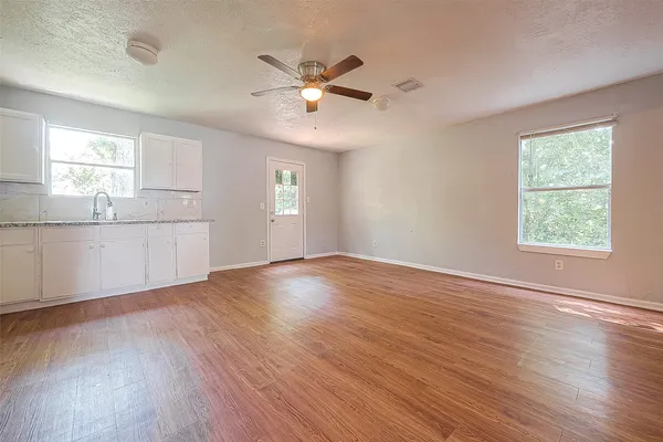 a view of a kitchen with wooden floor and a window