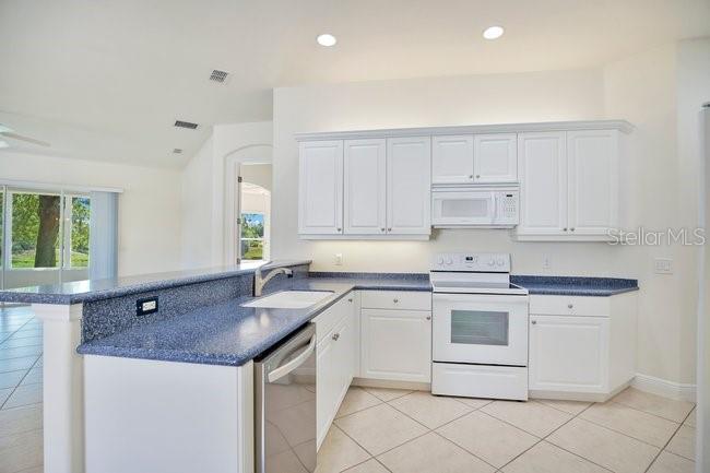 208 Lamonte Pointe Circle DeBary, FL 32713 - Photo 15 of 47 a kitchen with granite countertop white cabinets white appliances and sink