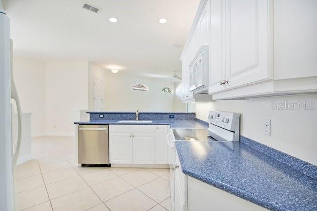 208 Lamonte Pointe Circle DeBary, FL 32713 - Photo 16 of 47 a kitchen with stainless steel appliances granite countertop a sink a stove and white cabinets