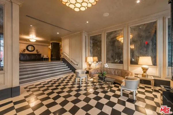 a living room with a black white checkered floor with a gaming machine and dining table