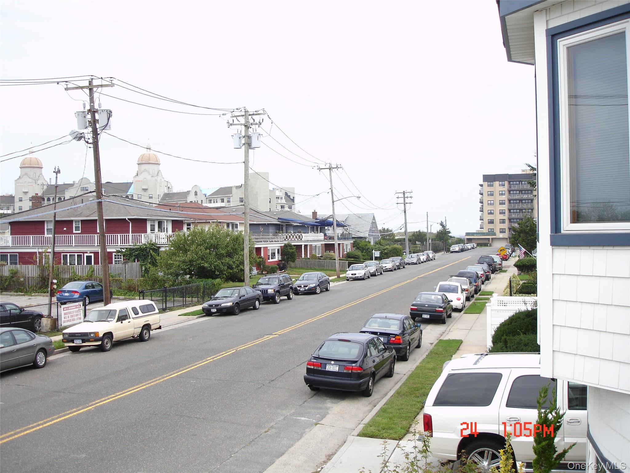 129 Maple Boulevard, Unit UPPR Long Beach, NY 11561 - Photo 12 of 13 a view of a city street with cars and a car parked on the road
