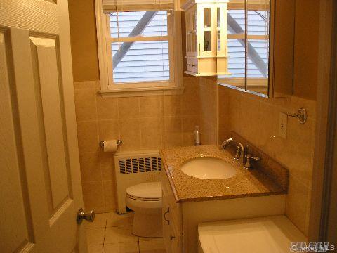 129 Maple Boulevard, Unit UPPR Long Beach, NY 11561 - Photo 3 of 13 a bathroom with a sink and a mirror