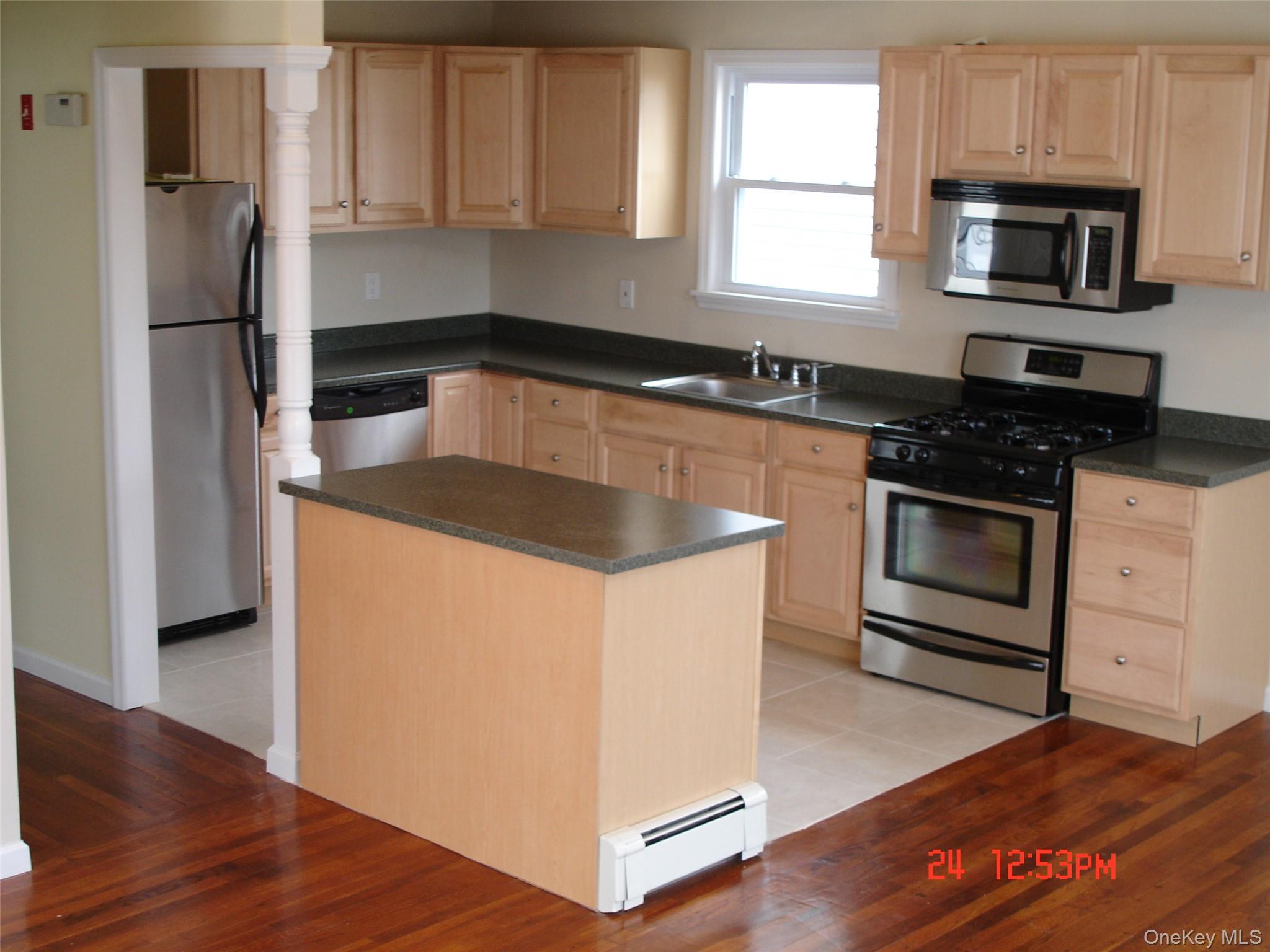 129 Maple Boulevard, Unit UPPR Long Beach, NY 11561 - Photo 5 of 13 a kitchen with granite countertop a sink stove and refrigerator