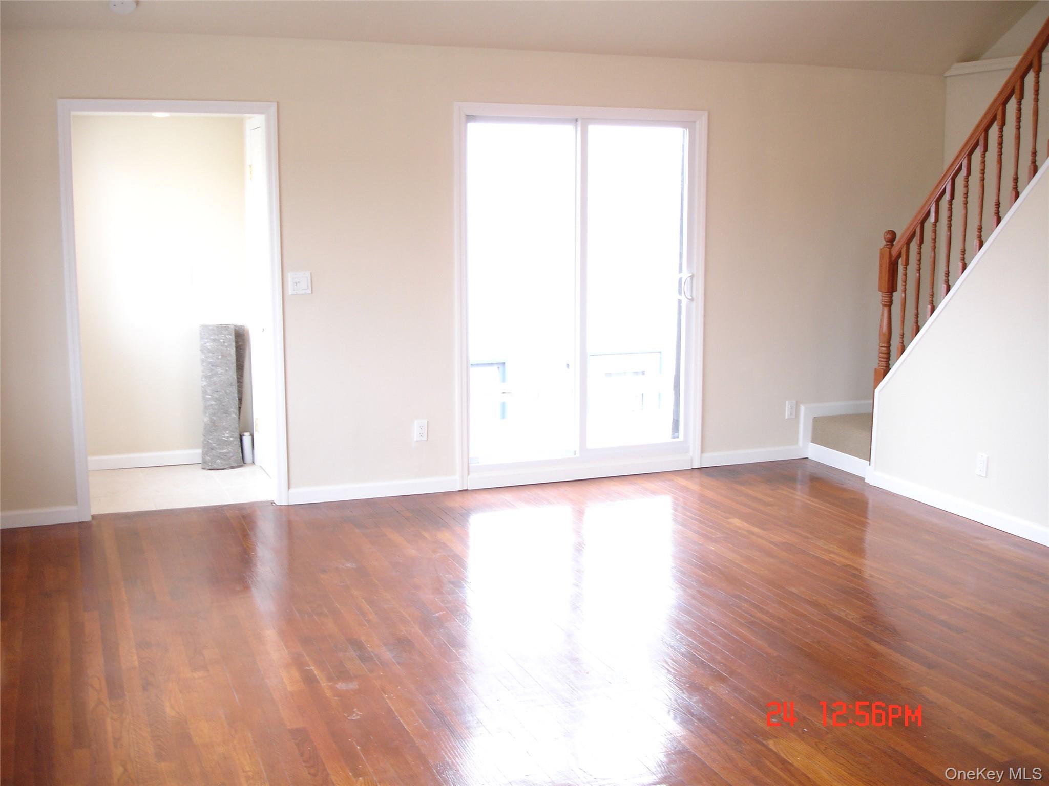129 Maple Boulevard, Unit UPPR Long Beach, NY 11561 - Photo 8 of 13 a view of an empty room with wooden floor and a window