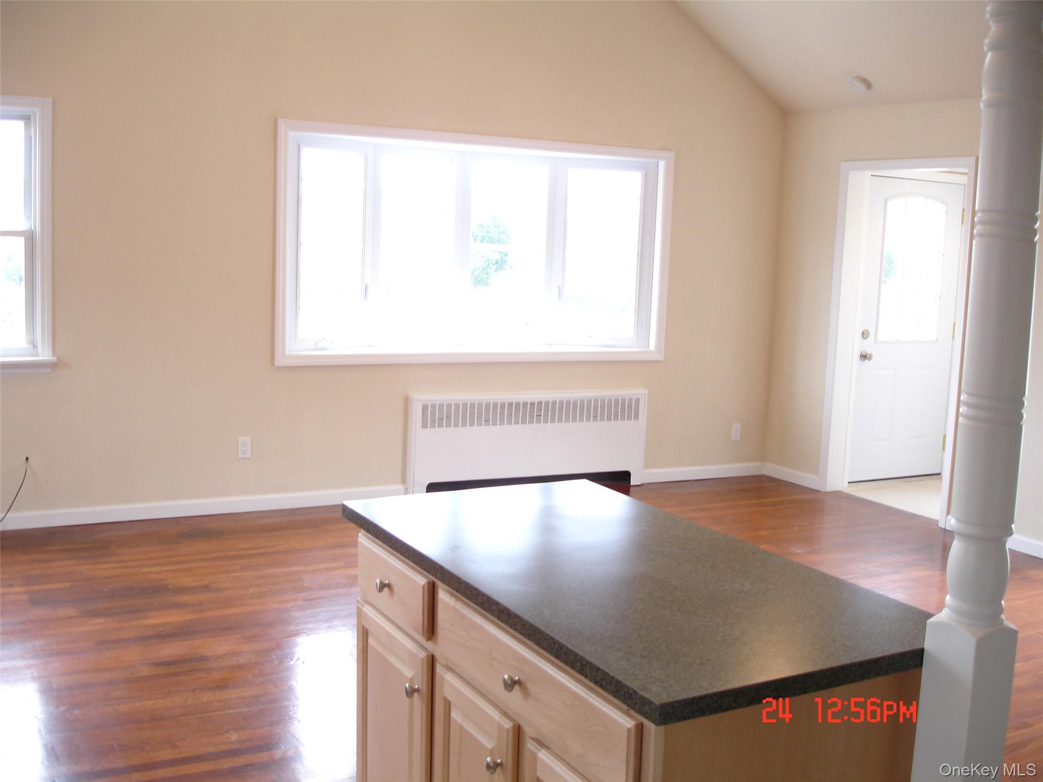 129 Maple Boulevard, Unit UPPR Long Beach, NY 11561 - Photo 9 of 13 an empty room with wooden floor and windows