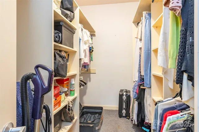 a view of walk in closet with clothes and shoes