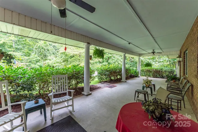 a view of a patio with table and chairs potted plants with floor to ceiling window