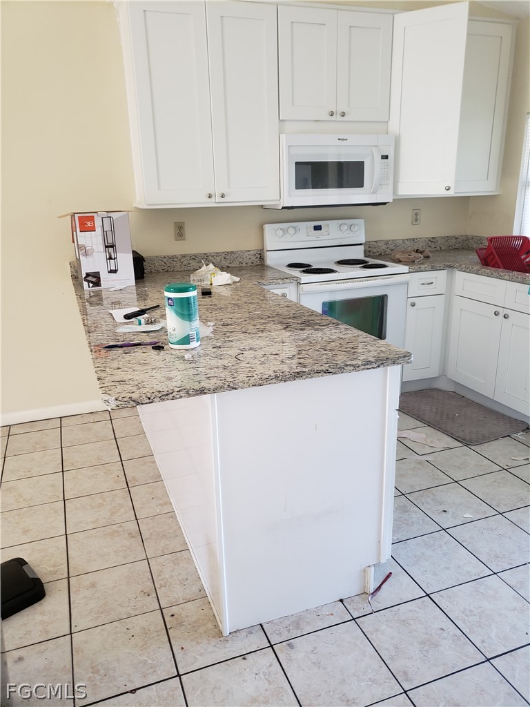 7491 Love Road Fort Myers, FL 33967 - Photo 5 of 5 a kitchen with a sink a stove top oven and white cabinets