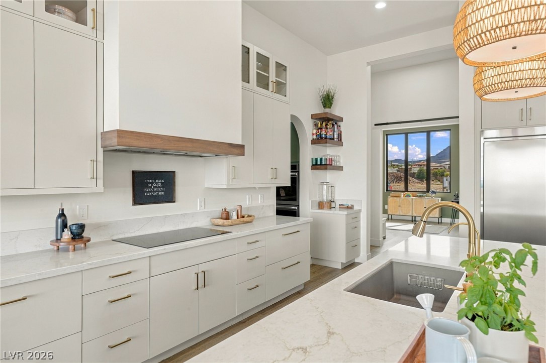 324 Wanda Road Henderson, NV 89002 - Photo 18 of 96 Clean lines and stone counters define this modern kitchen containing a large central island.
