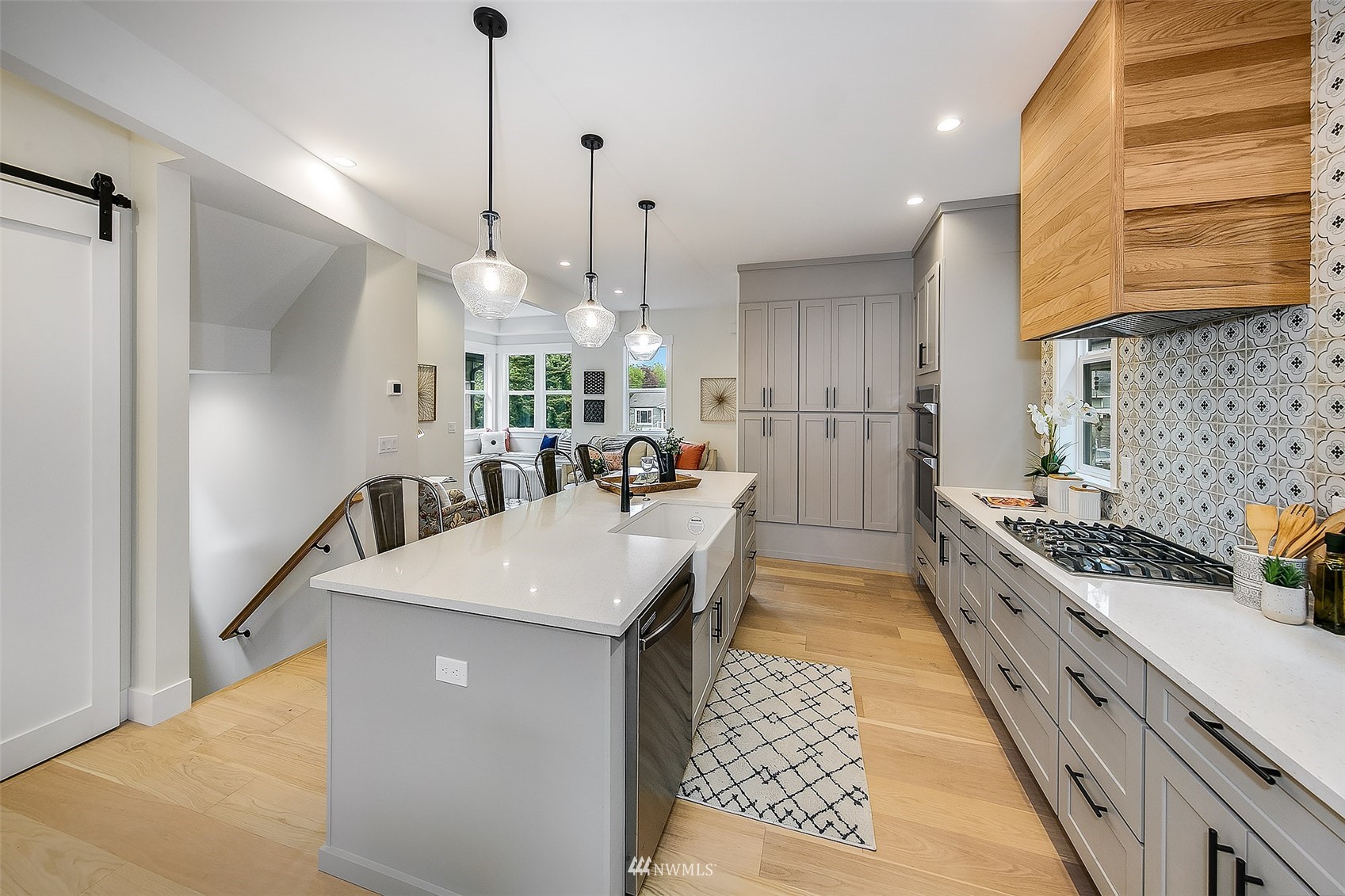 2143 6th Avenue West Seattle, WA 98119 - Photo 11 of 31 a kitchen with stainless steel appliances granite countertop a sink a stove and a wooden floor