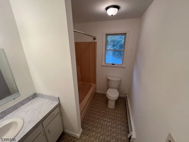 a bathroom with a granite countertop toilet and a sink