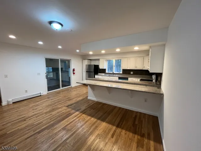 a large kitchen with stainless steel appliances kitchen island a large counter top and a stove top oven