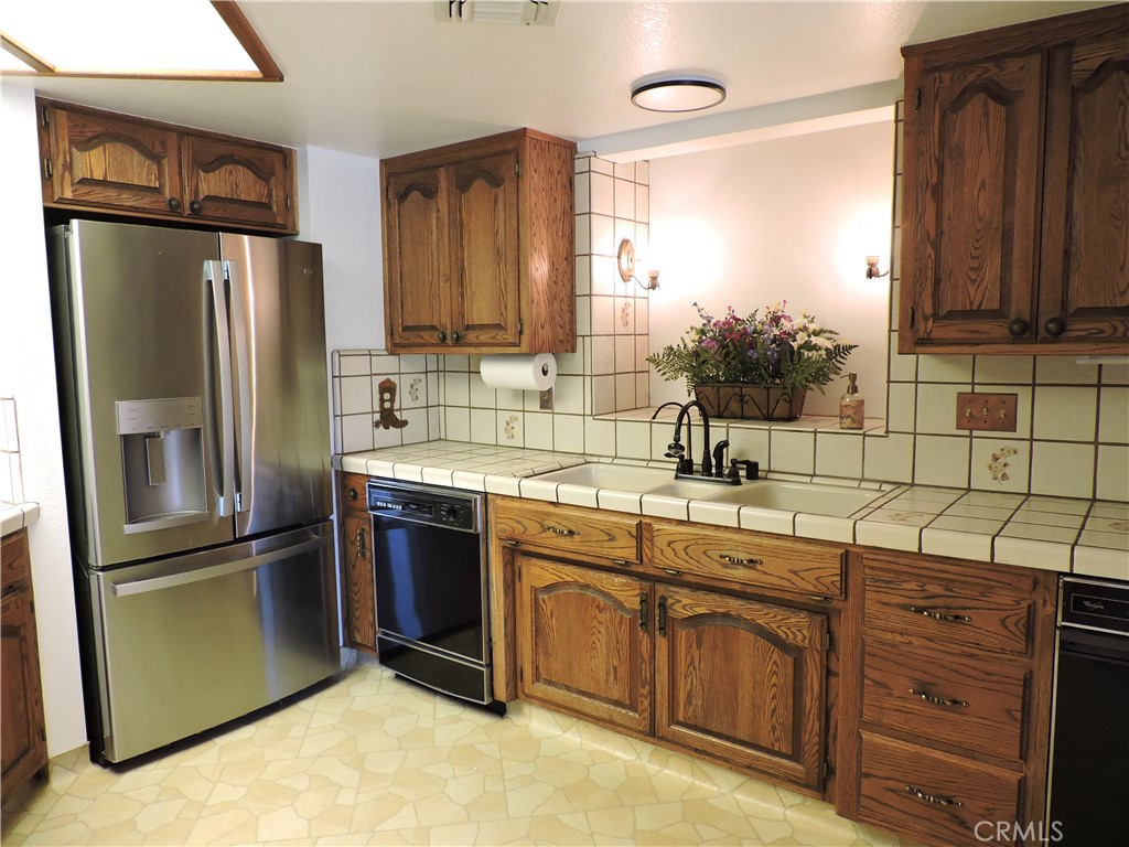 26931 Columbia Way Tehachapi, CA 93561 - Photo 33 of 49 Original Country Kitchen with Plenty of Cabinets and Counter Space. Stainless Steel Refrigerator, dishwasher and 3 separate sinks make for a wonderful cooking space!