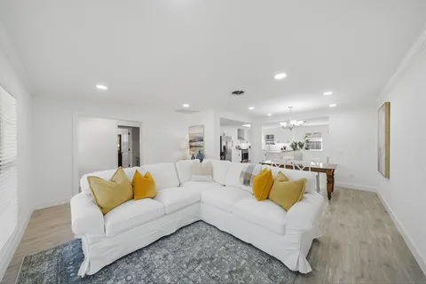 a living room with furniture and white wooden floor