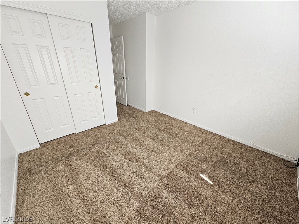 2817 Albemarle Way Henderson, NV 89014 - Photo 12 of 25 A spacious bedroom offers comfort with soft carpeting and ample closet space.