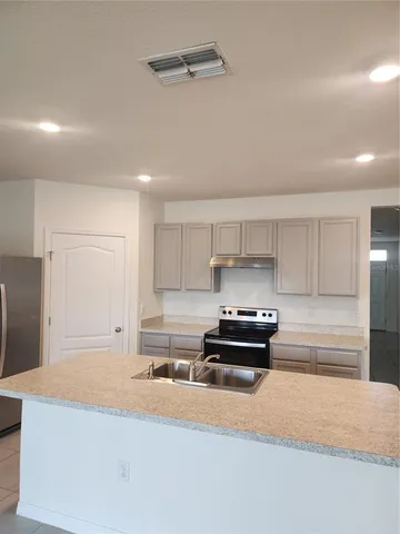 a kitchen with granite countertop a stove and a refrigerator