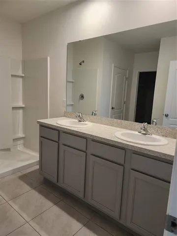 a bathroom with a double vanity sink and mirror