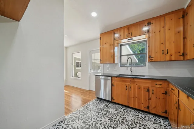 a kitchen with stainless steel appliances granite countertop a sink and a granite counter tops with wooden floors