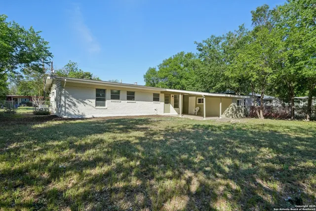 a white house that has tree in front of it