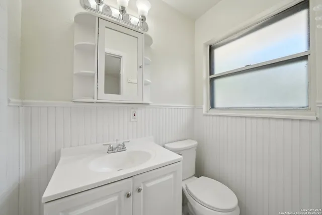 a bathroom with a sink a toilet and a mirror