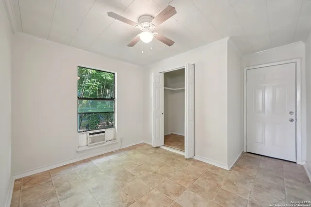 an empty room with windows and closet