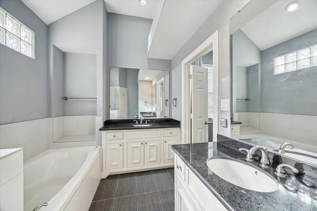 a spacious bedroom with a bed and a flat tv screen