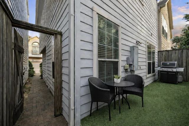 a kitchen with stainless steel appliances granite countertop a stove a refrigerator a microwave a dining table and chairs with wooden floor