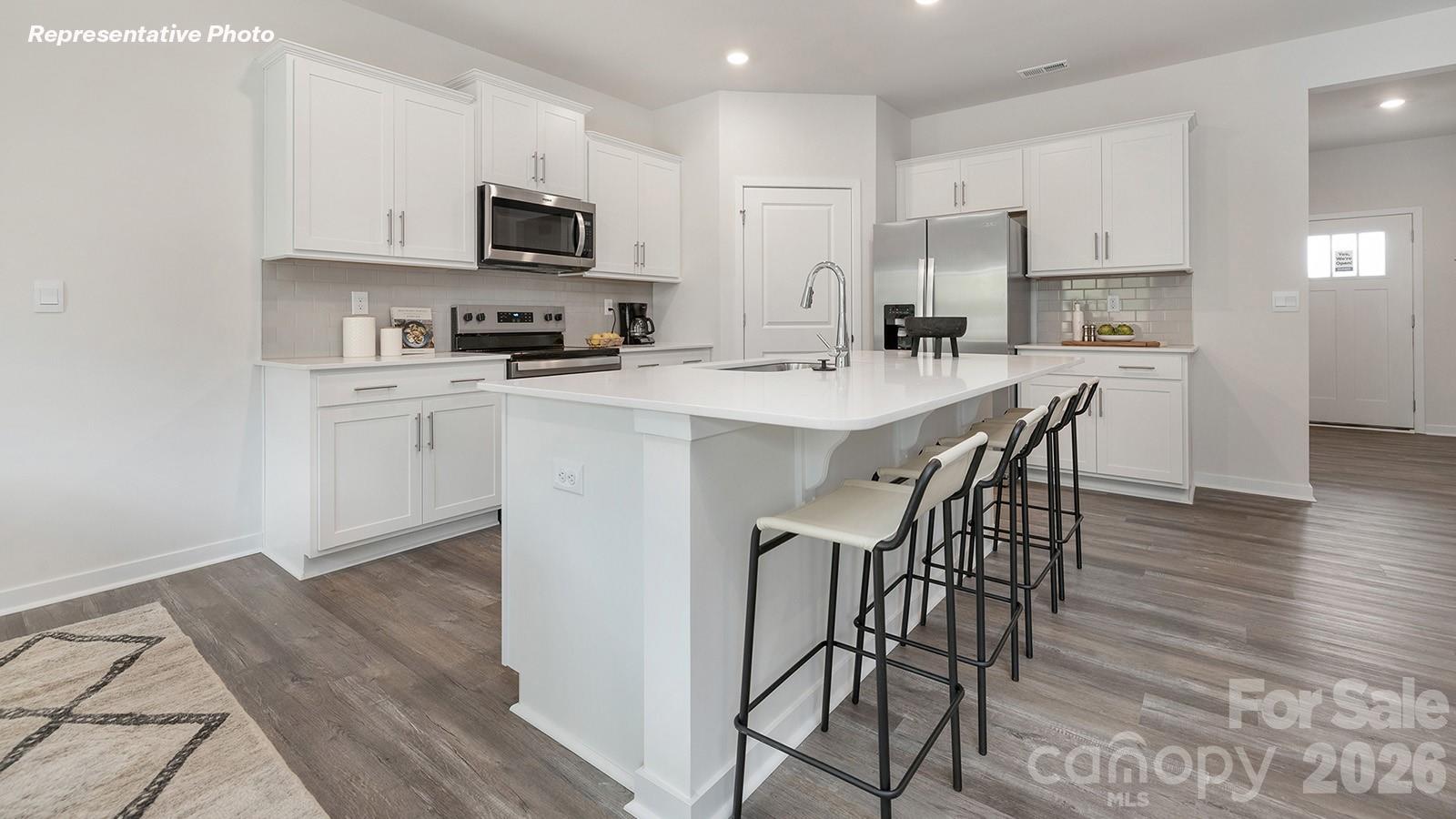 4560 Harris Elliot Road Lincolnton, NC 28092 - Photo 3 of 34 a kitchen with stainless steel appliances a microwave a stove a sink a stove a dining table and chairs