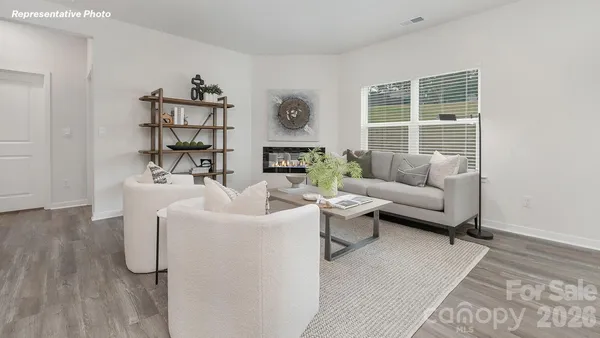 a living room with furniture wooden floor and a large window