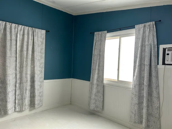 a bedroom with a bed and a chandelier fan