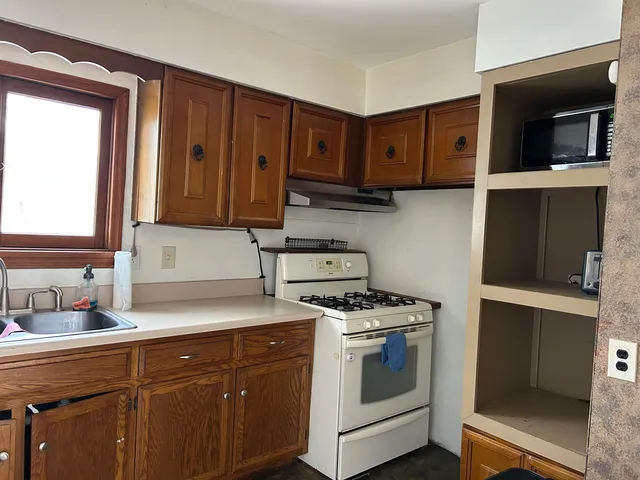 a kitchen with stainless steel appliances granite countertop a stove a sink and a microwave