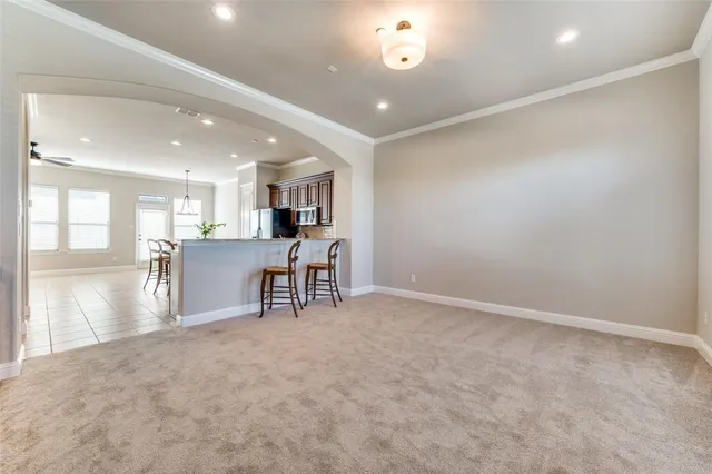a view of a kitchen with large windows and chairs