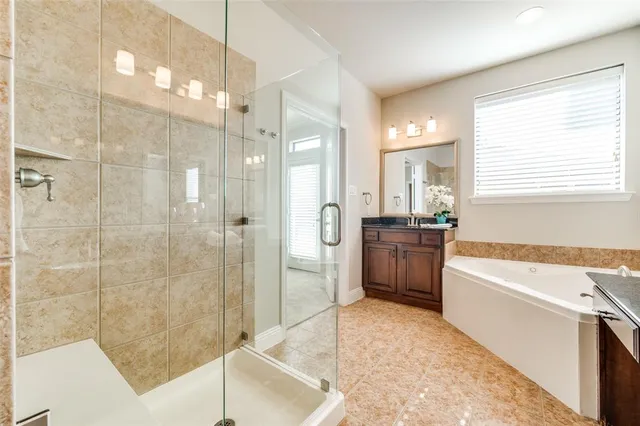 a bathroom with a tub sink shower and a mirror