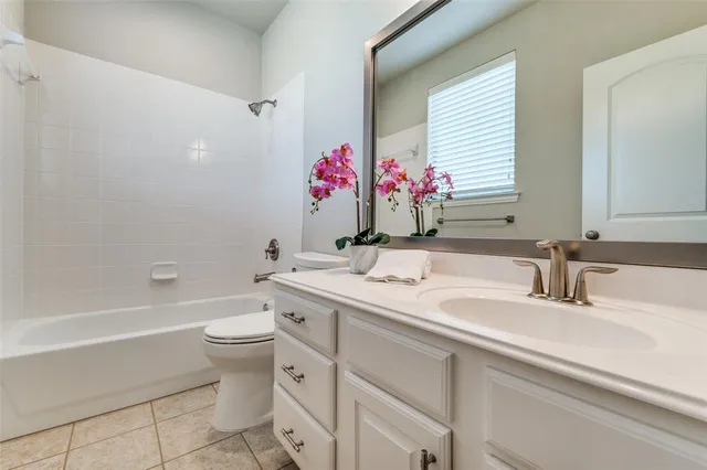a bathroom with a granite countertop sink mirror vanity and toilet