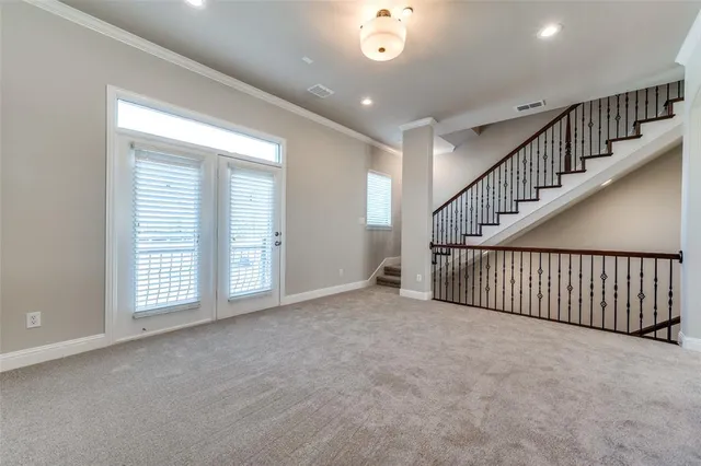 a view of an empty room with stairs and a window